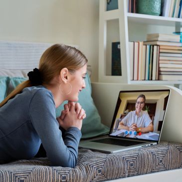 Young woman video chatting on a laptop at home.