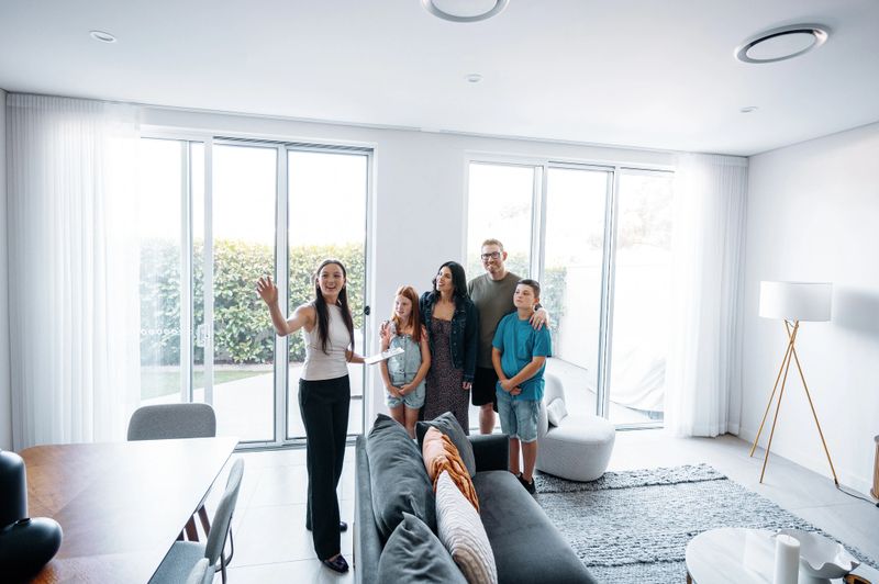 Family with kids buying new house and talking to real estate agent