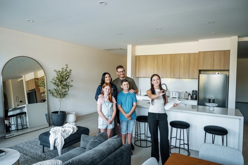 Family with kids buying new house and talking to real estate agent