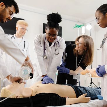 Medical team practicing CPR on a training mannequin in a clinical setting.
