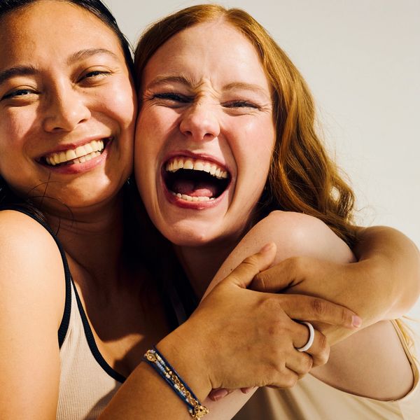 Two women joyfully hugging and laughing together.
