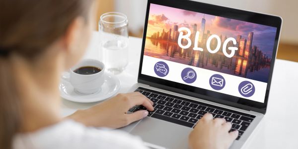 Person typing on laptop with 'BLOG' on screen.
