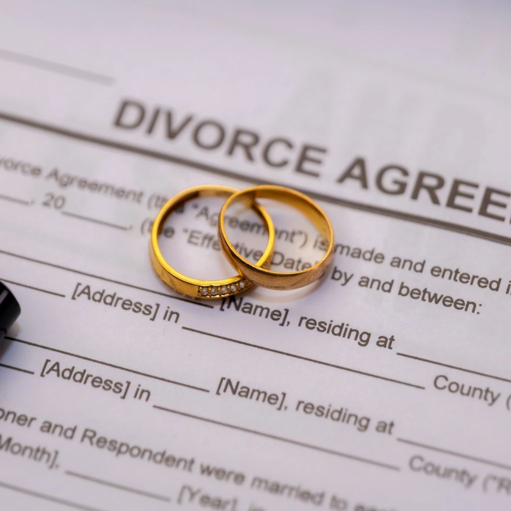 Two gold rings on a divorce agreement document.