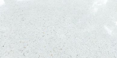 Polished white terrazzo floor with scattered light-colored stone chips.