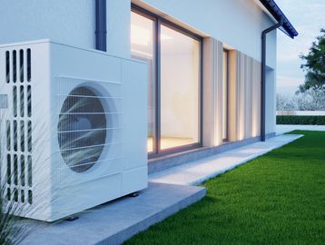 Outdoor air conditioning unit beside a modern house.