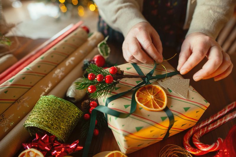 Close-up of a woman's hands wrapping Christmas presents