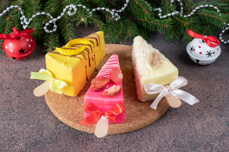 Banana, strawberry and coconut cheesecake on stick in festive design