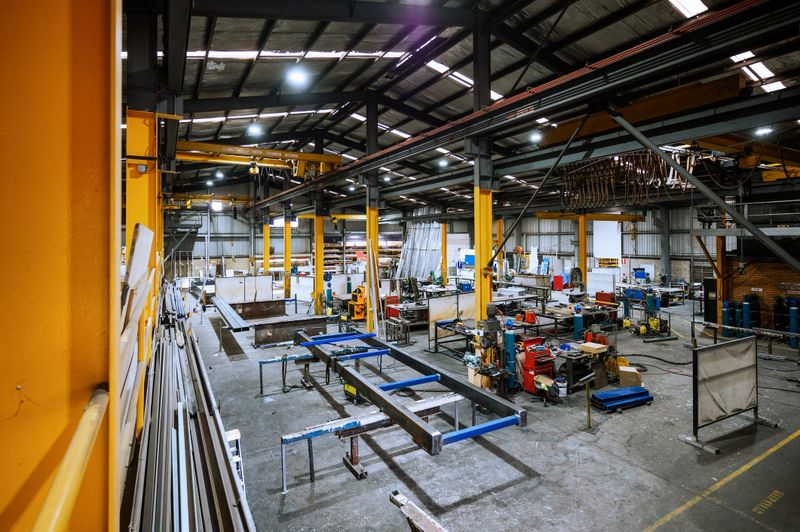 Large industrial warehouse with machinery and yellow support structures , with steel and metal processing equipment