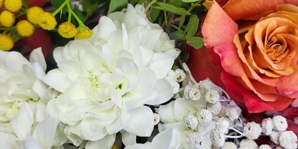 Close-up of a vibrant flower bouquet with white, orange, and yellow blooms.
