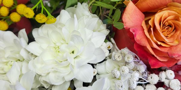 Close-up of a vibrant flower bouquet with white, orange, and yellow blooms.
