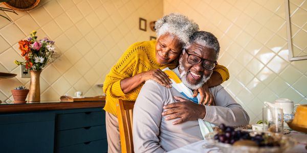 Elderly couple sharing a joyful moment in the kitchen.