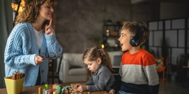 Woman teaching children with letter tiles and games.