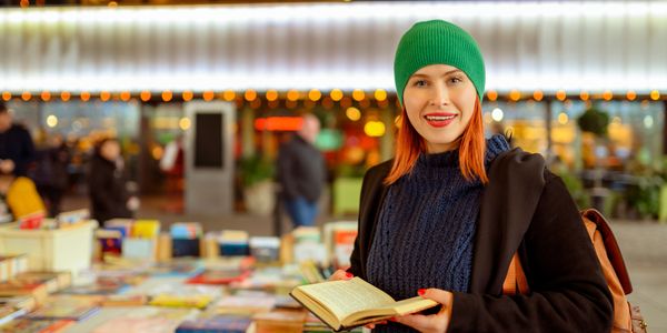 A boy walking on a drawn book with clouds and birds in the background.