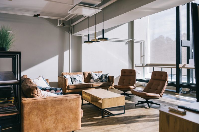 An airport VIP business lounge with empty chairs and a large, open floor plan, featuring stylish furniture and a relaxing environment