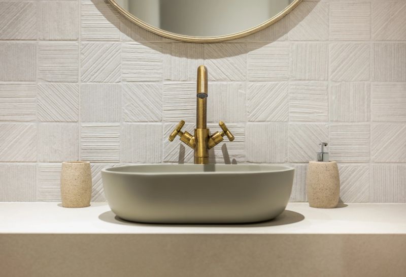 This stylish bathroom setup showcases a modern sink paired perfectly with an elegant brass faucet accent