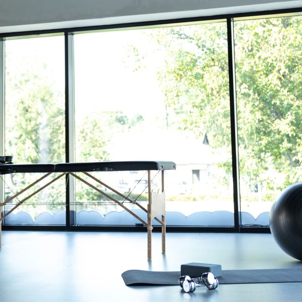 A clean clinic space with table, weights, and exercise ball. 