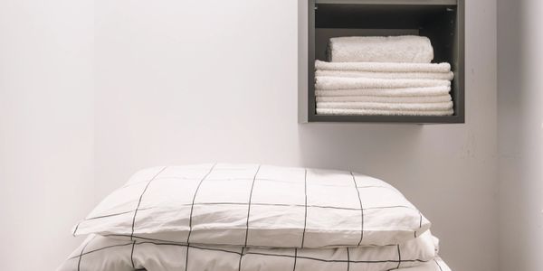 Organized laundry room with washer, folded linens, and neatly arranged toiletries and towels.