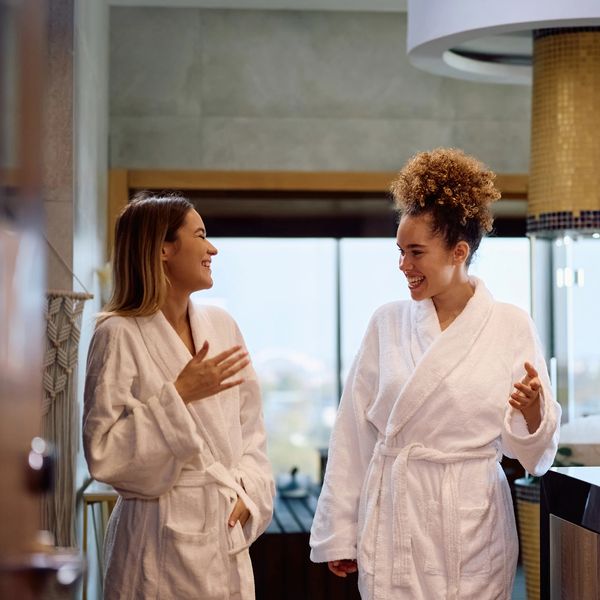 Two women in robes are enjoying a day at a full-service spa