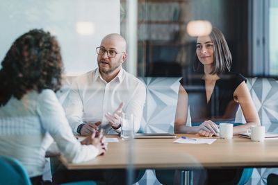 Two people interviewing a woman in a modern office.