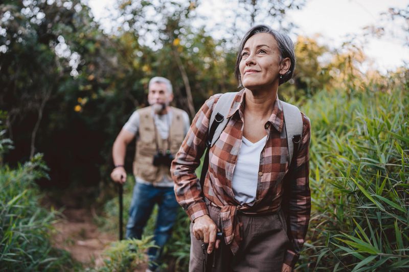 Senior couple walking on forest mountain trail