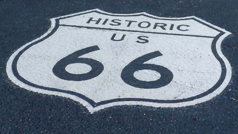 Historic Route 66 road sign painted on asphalt, iconic symbol of the legendary American highway