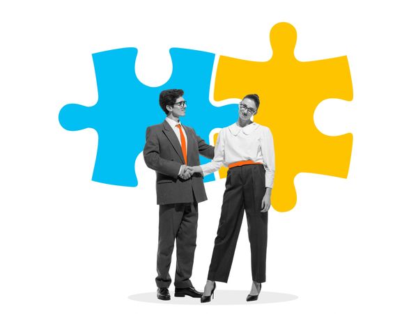 Two professionals shaking hands with puzzle pieces symbolizing teamwork in the background.
