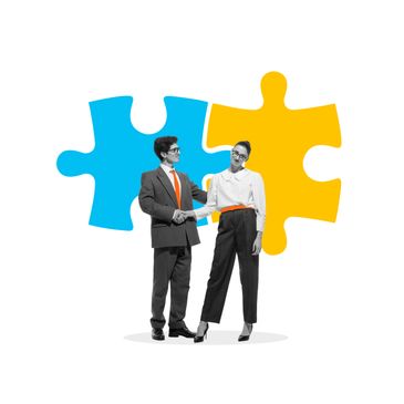 Businessman and businesswoman shaking hands with colorful puzzle pieces in background.