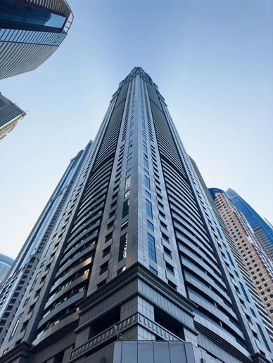 A towering modern skyscraper against a clear blue sky.