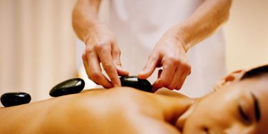 Person receiving hot stone massage on their back.