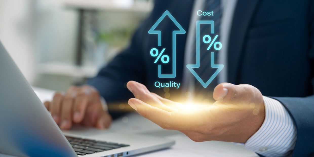 Businessman shows quality up, cost down concept on laptop.