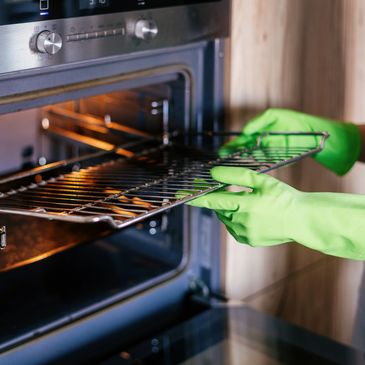 Gloved hands taking racks out of an oven