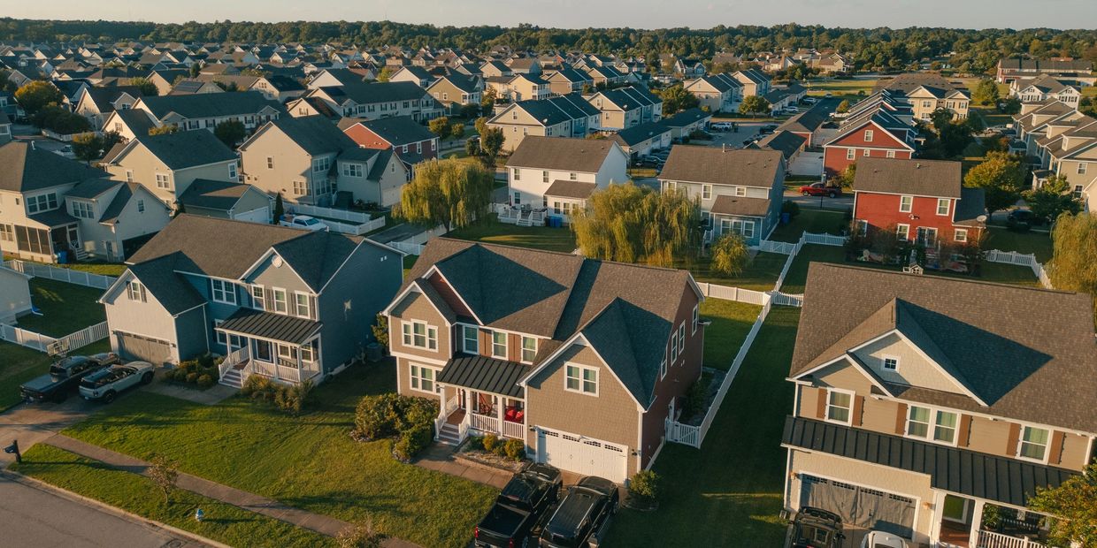 Aerial view of a suburban neighborhood with many houses and green lawns.