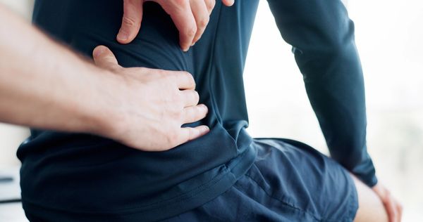 Person receiving a back massage or physical therapy for lower back pain.