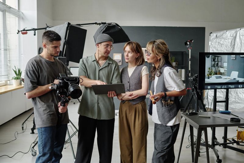 Director showing script and discussing details of shooting day while his best cameraman sitting device