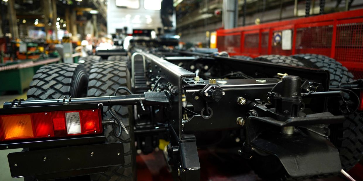 Close-up of truck chassis and wheels in an industrial assembly line.