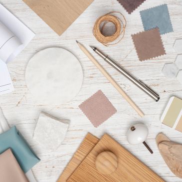 Crafting and design tools on a white wooden surface.