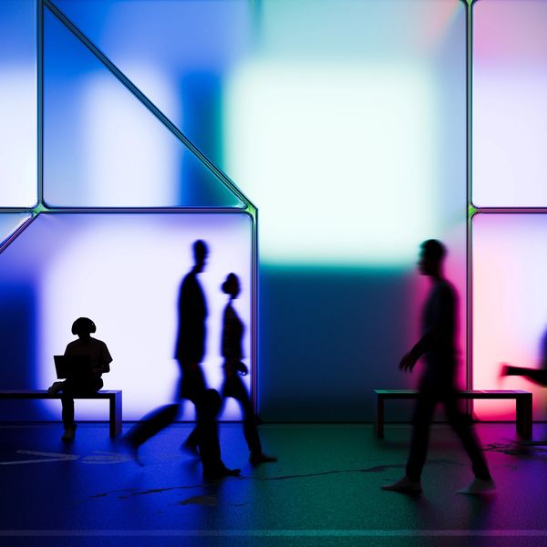 Group of people spread out walking in shadows.
