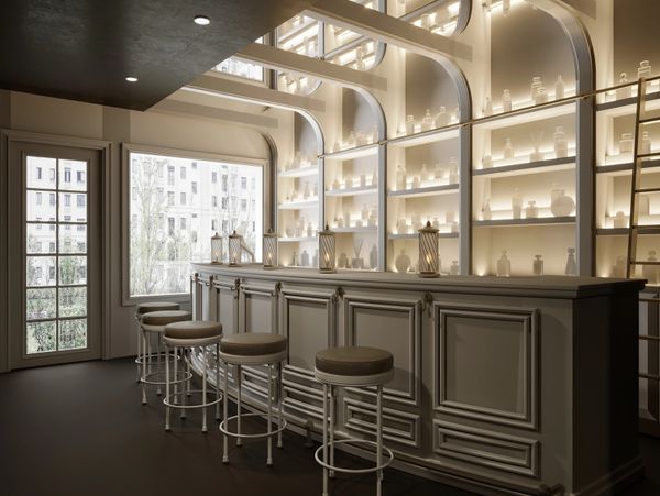 Elegant bar with softly lit shelves and cushioned stools in a modern, minimalist setting.