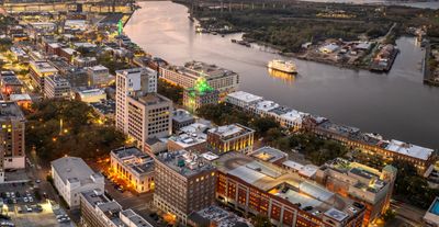 Aerial view of a cityscape at dusk with a river running through it.
