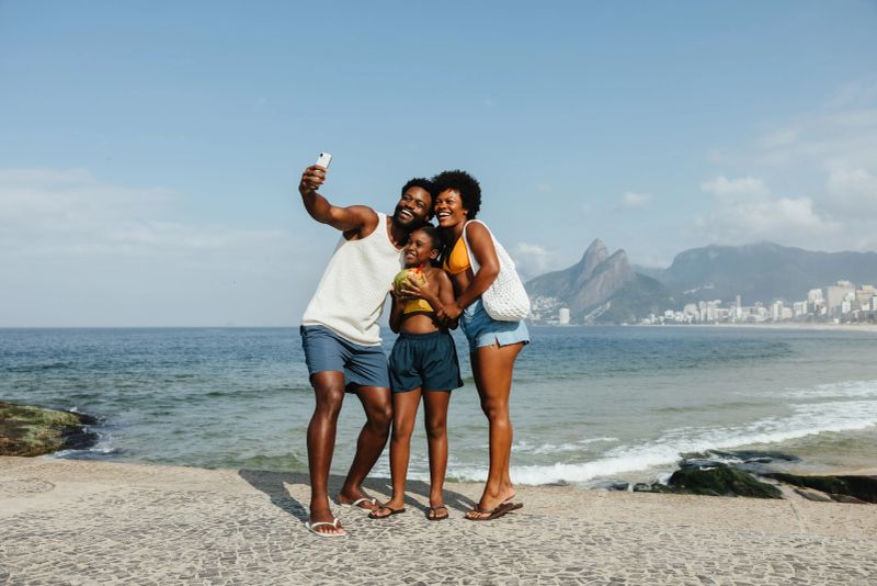 A joyful family captures a selfie on the iconic Ipanema Beach in Rio de Janeiro. A relaxed vacation scene, with the family radiating warmth and unity, highlighting the beauty of shared experiences.