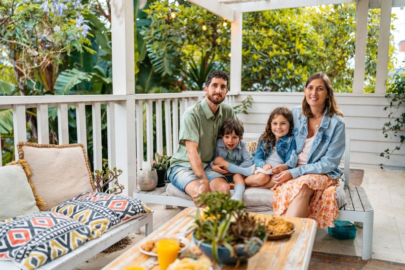 Portrait of a young family sitting on the patio outdoors in Sydney in Australia.