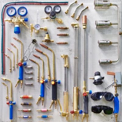 Organized display of welding and cutting torch equipment on a perforated board.