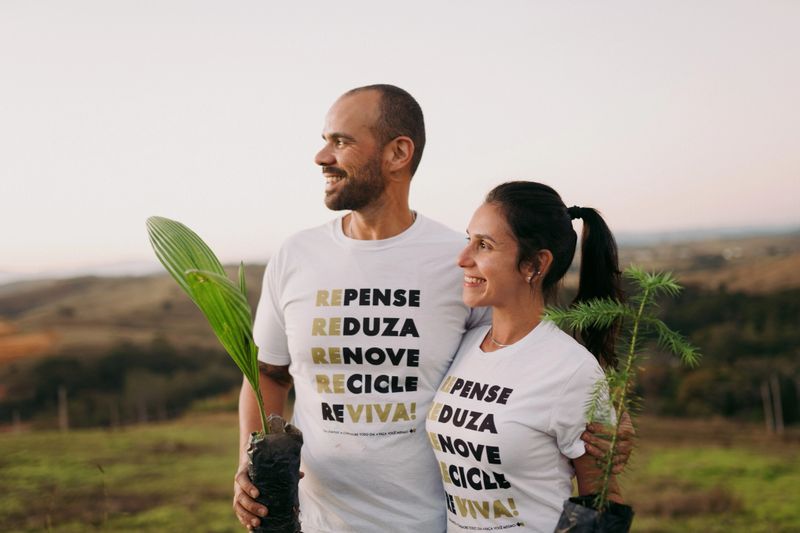 Contemplative couple holding tree seedlings