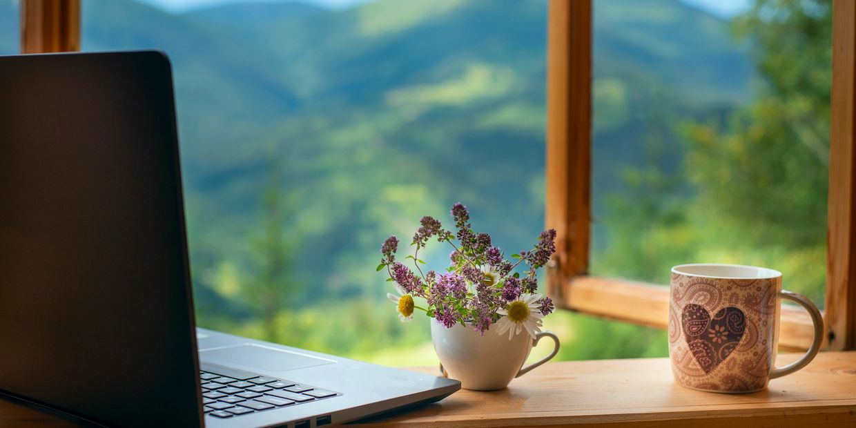 Laptop in windowsill overlooking the mountains