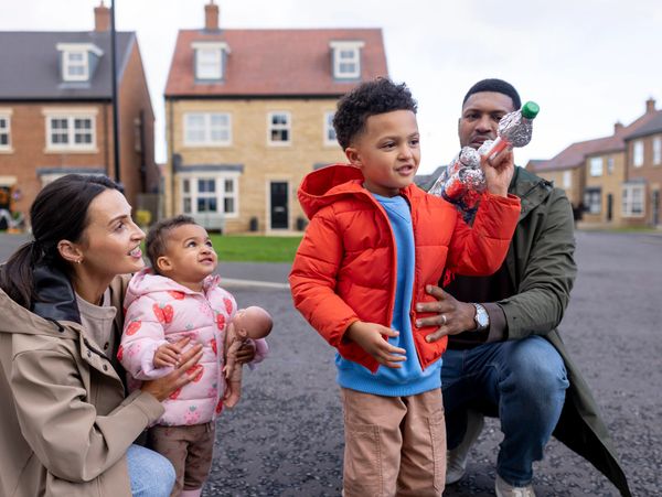 After healing ministry, a family enjoys a moment outside their home with kids playing and parents watching.