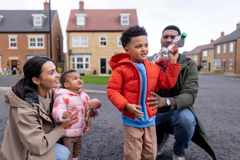 A medium shot of a multiracial family in a quiet suburban neighbourhood. They are all smiling and are wearing casual clothing.

Videos are available similar to this scenario.