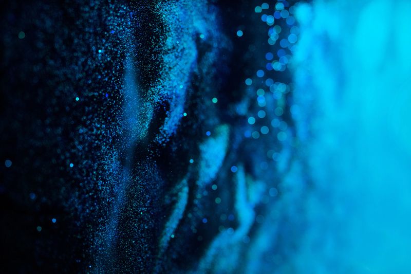 A mesmerizing closeup image of glistening and shimmering blue textures that resemble the serene depths of the ocean