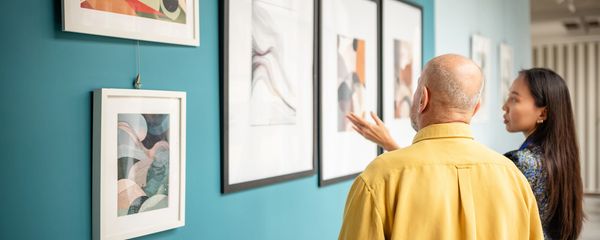 Two people observing abstract art in a gallery.