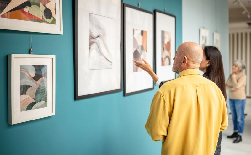 People engaged in viewing modern art at a gallery, including a curator discussing the pieces.