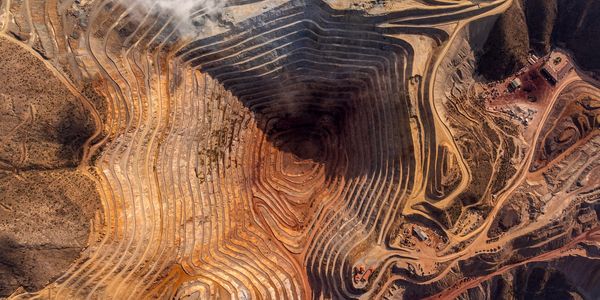 Aerial view of a large open-pit mine with terraced excavation.